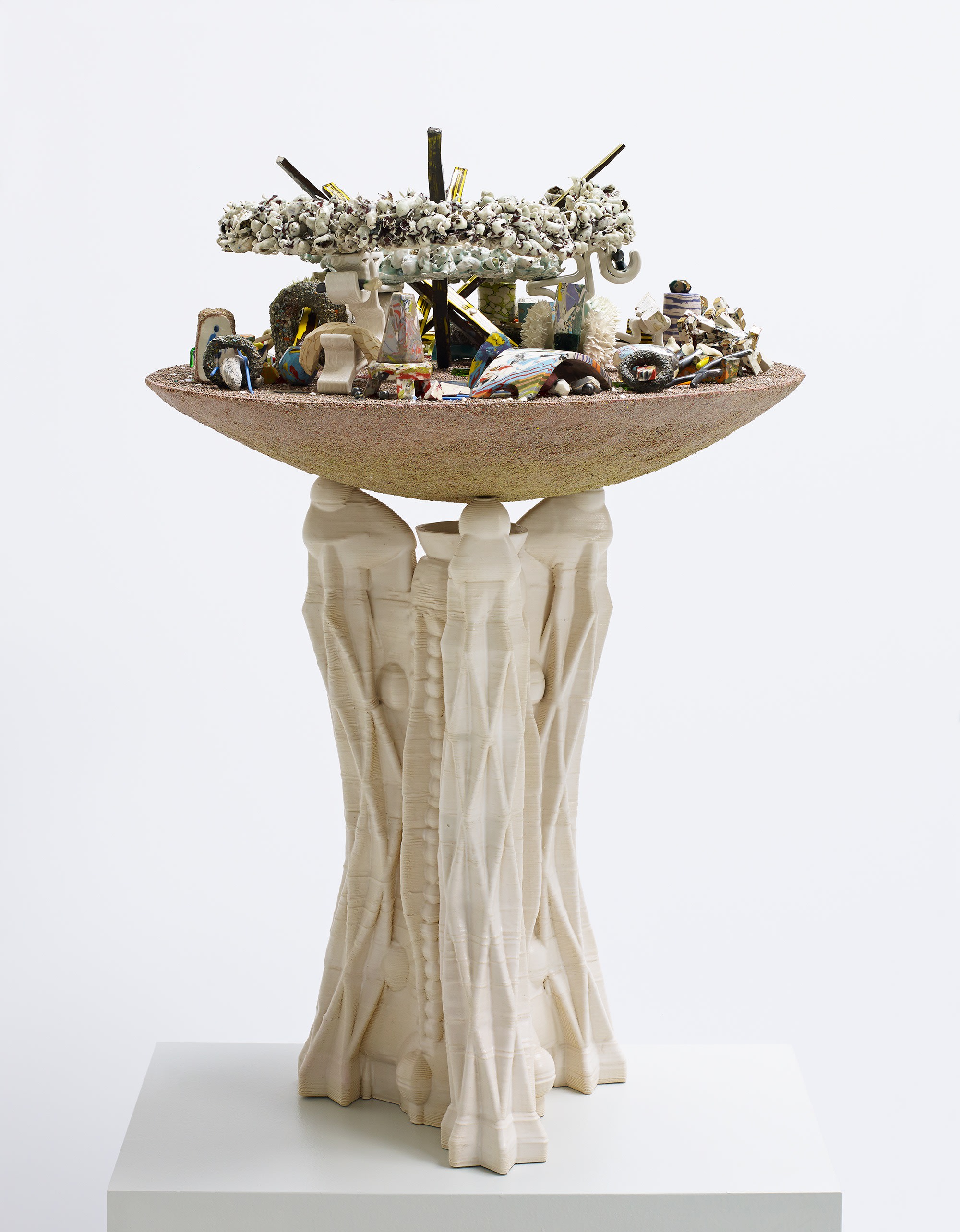 A sculpture that features a dish-like shape on a pedestal.