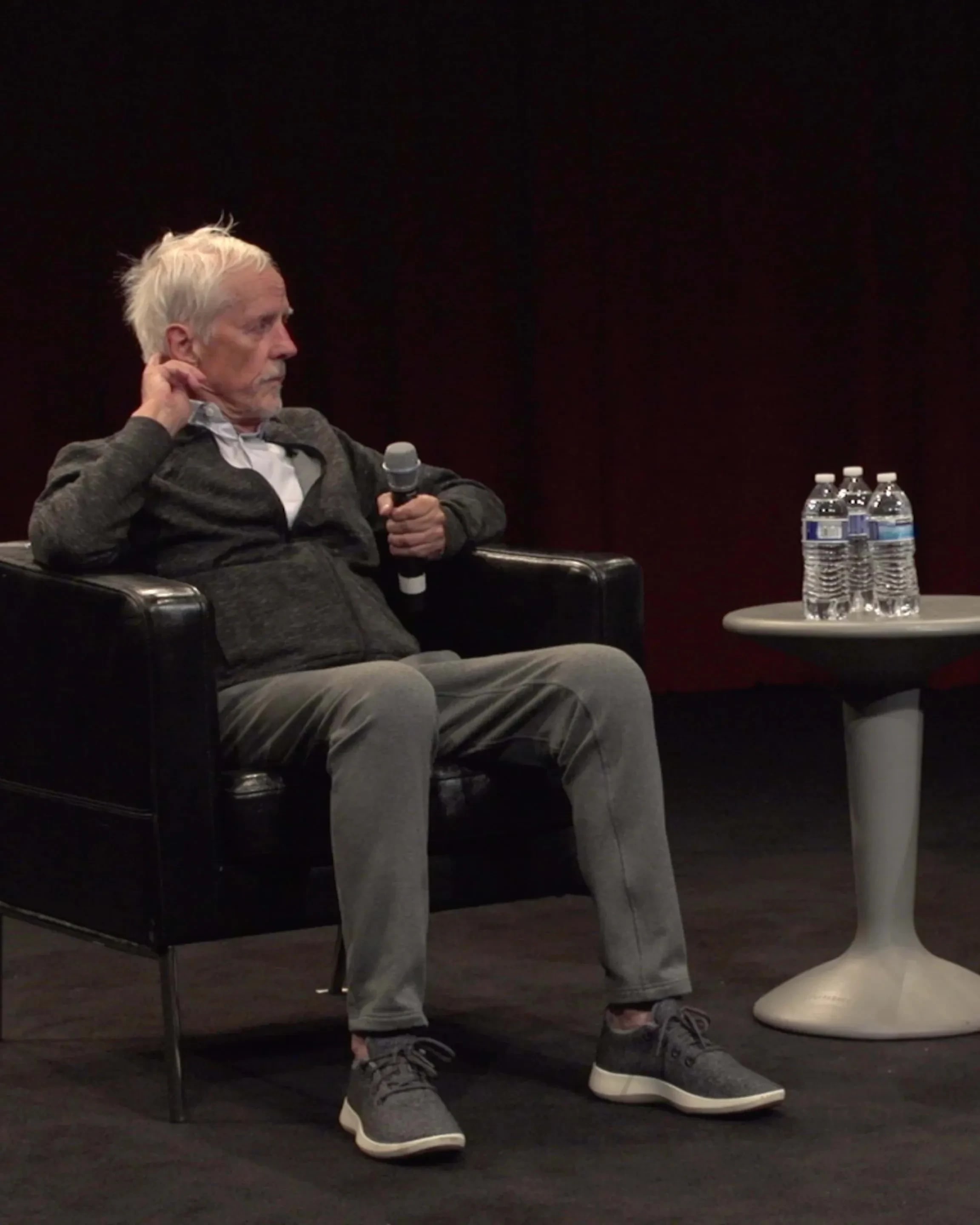 Two people sitting on stage talking.