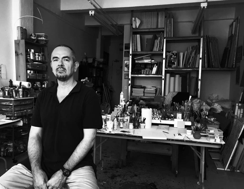 An image of a man sitting in an art studio