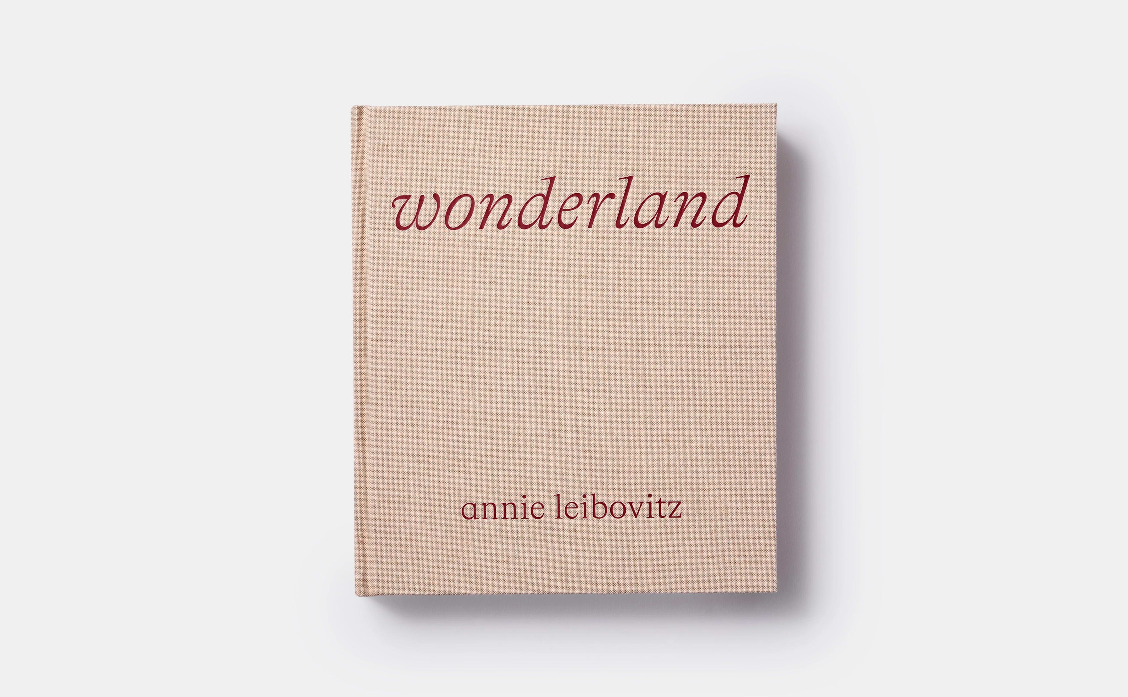 Color photograph of the cover of Annie Leibowitz's book "Wonderland". It's a hardcover book bound in beige cloth with red text for the book title and artist name.
