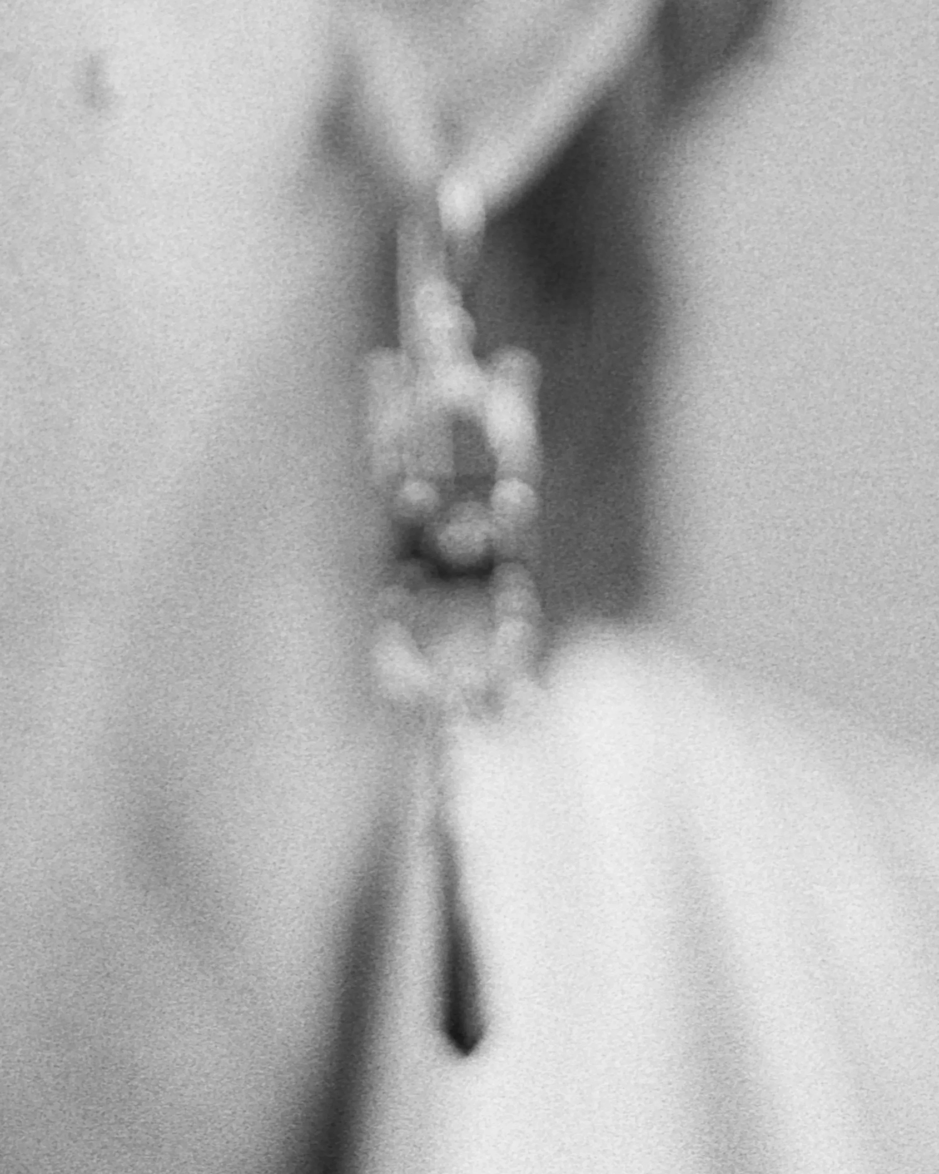 Blurry black and white photography of a dangling earring.
