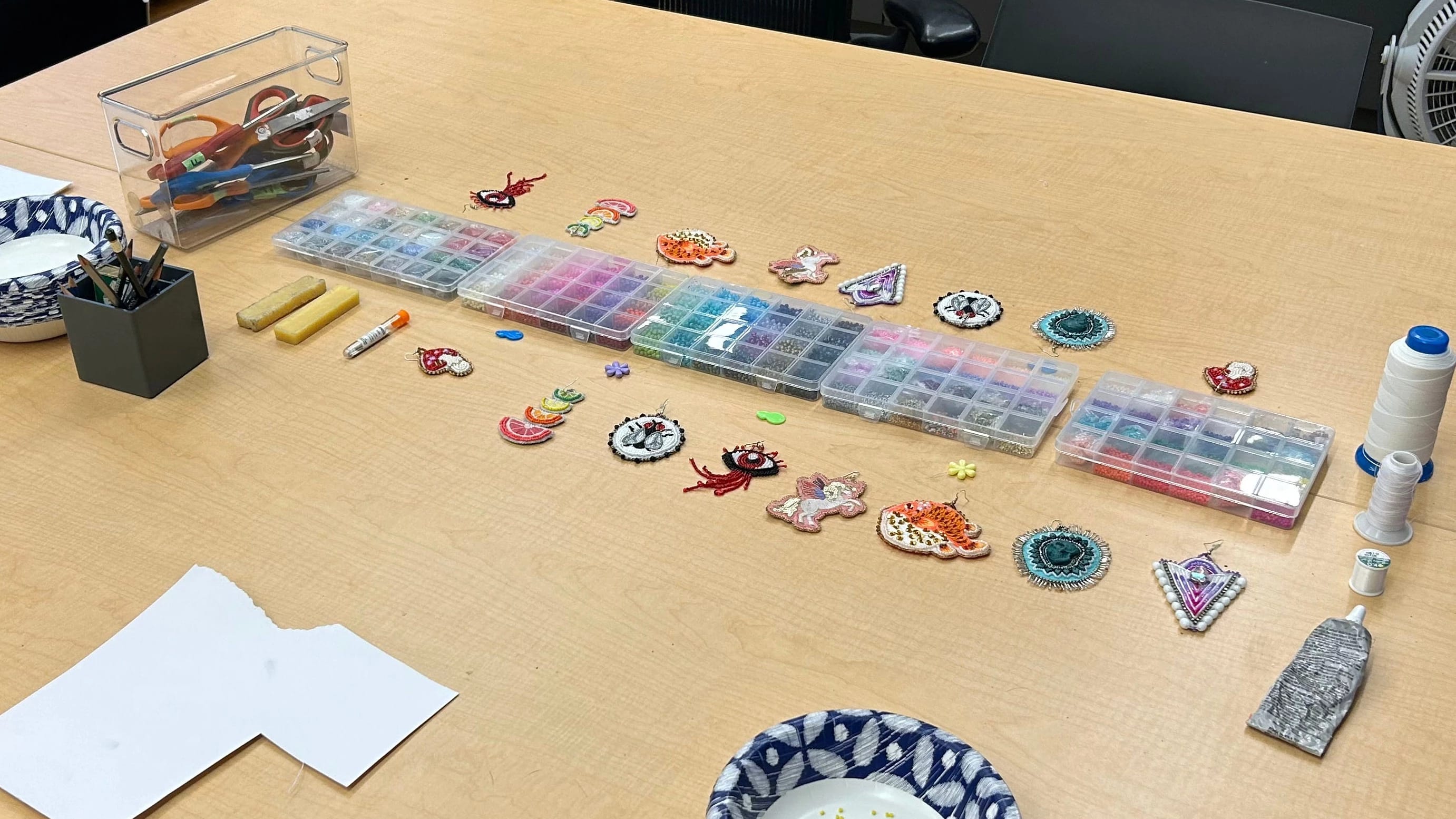 long wood table prepared with beading supplies for workshop 