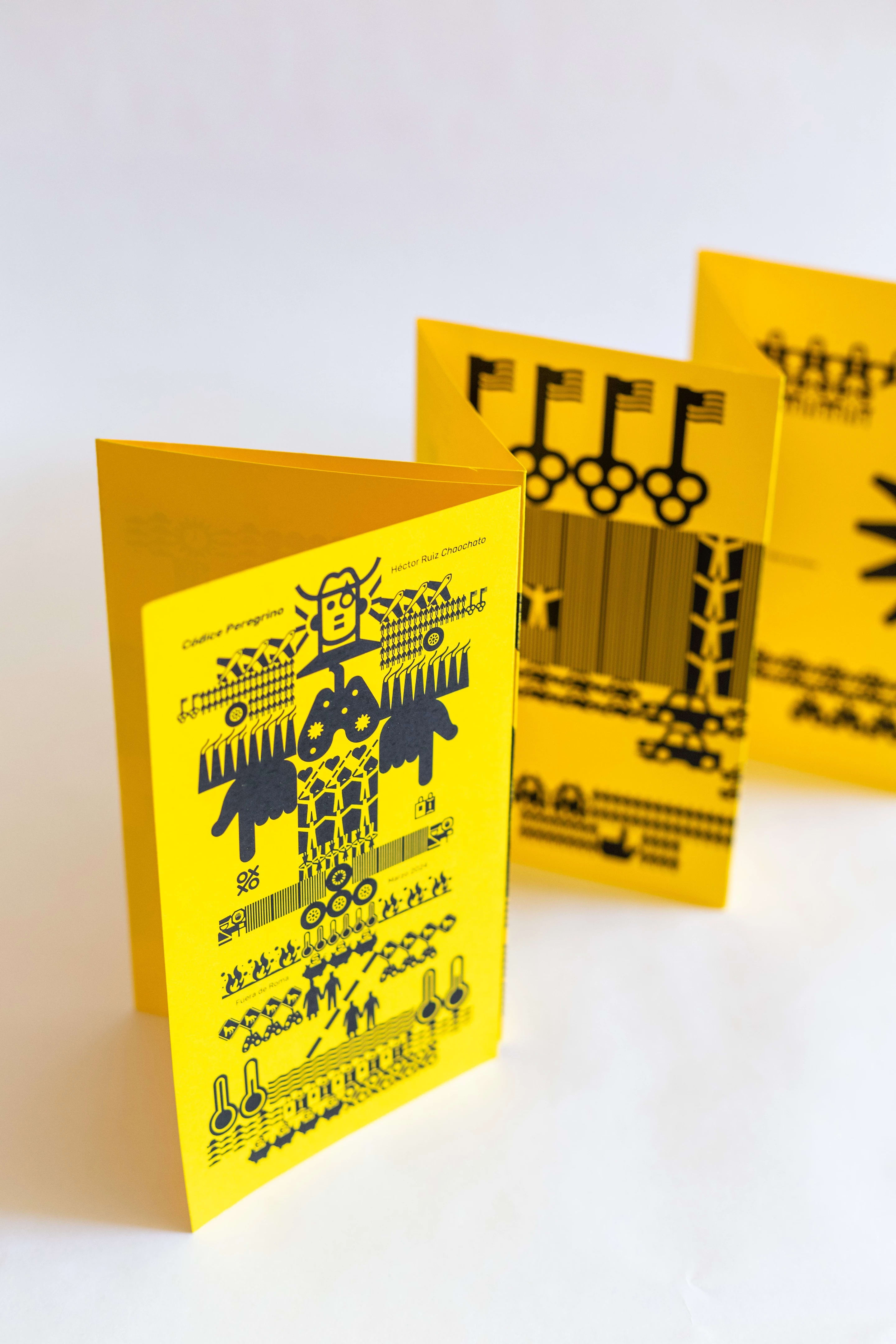 A yellow sheet of paper printed with black symbols like hieroglyphics but with images relating to Mexican heritage and culture.