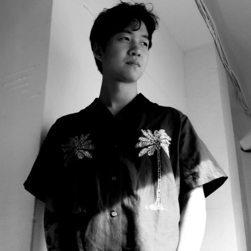 A black and white image of a young person looking off to the side.