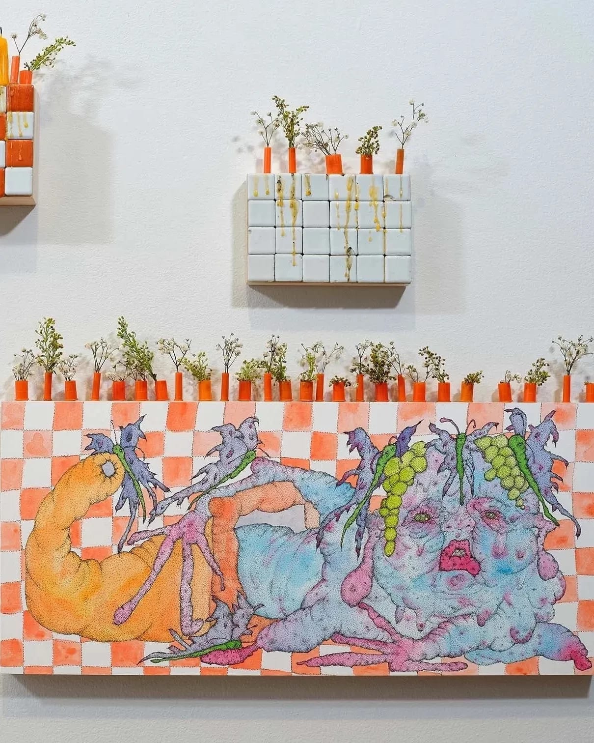 Orange and white checkered block with bulbous figure and greens on top