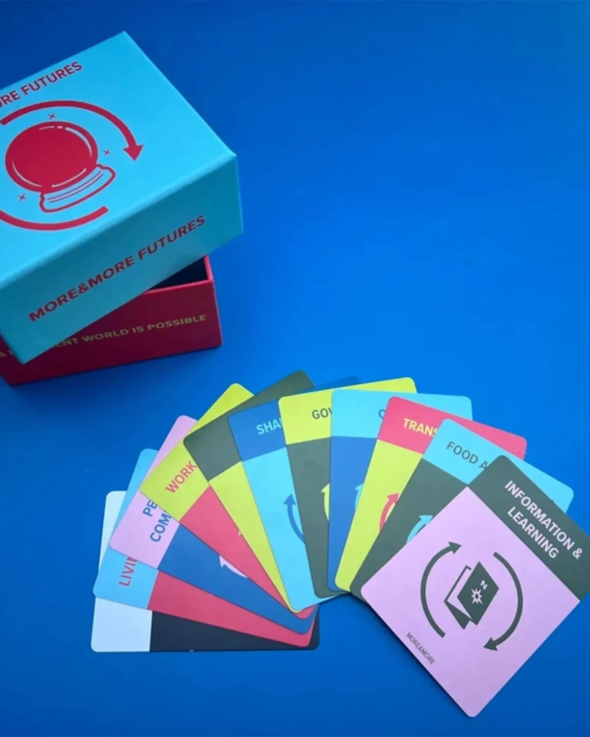 A hand of cards fanned out on top of a blue background. An open box is on the top left.