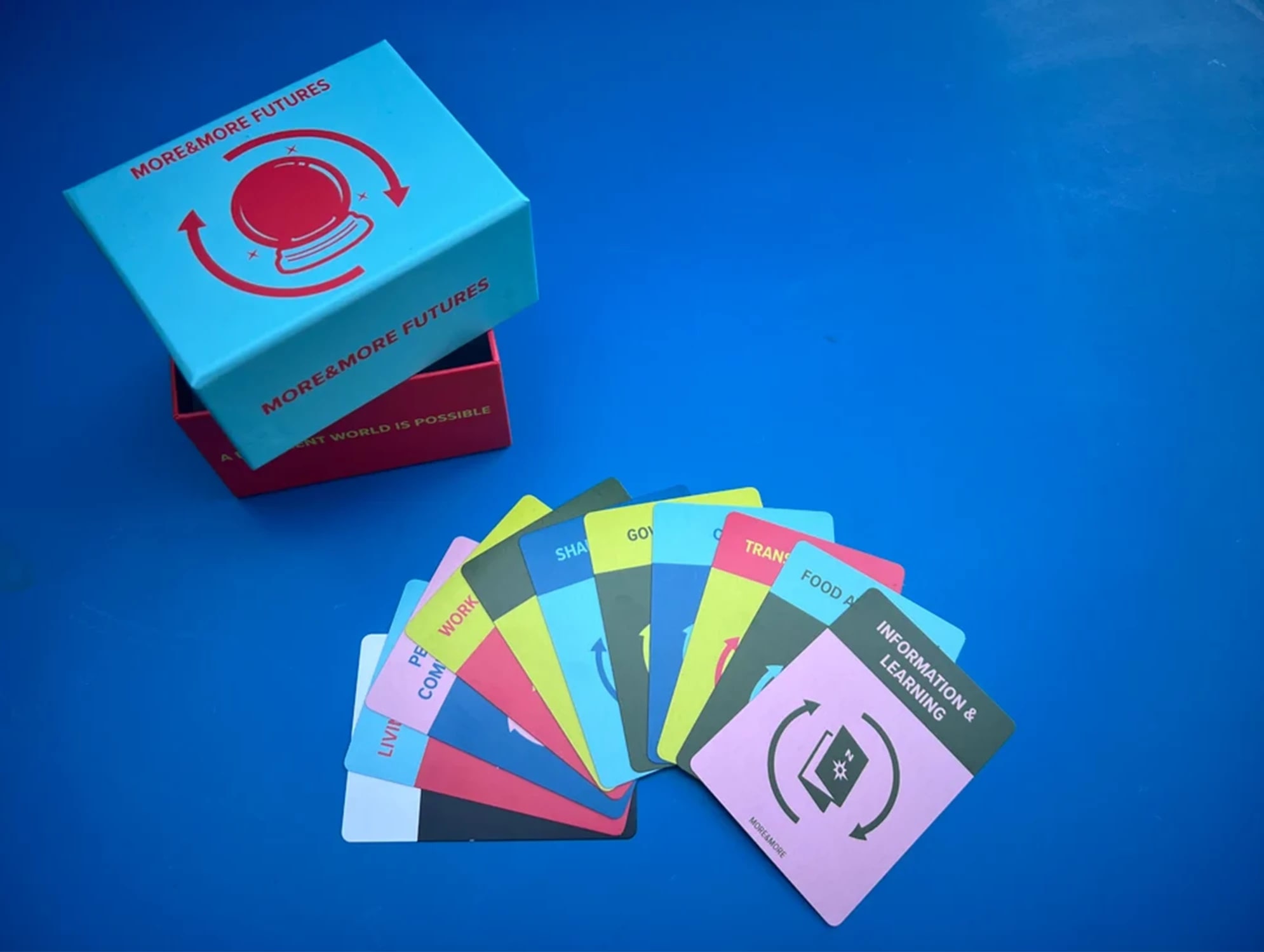 A hand of cards fanned out on top of a blue background. An open box is on the top left.