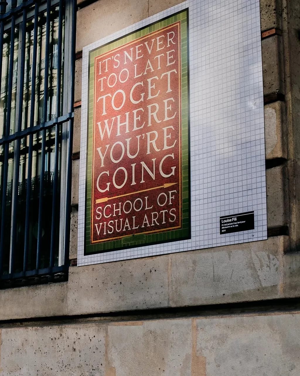 A close up shot of the side of a building, SVA posters up on the side.