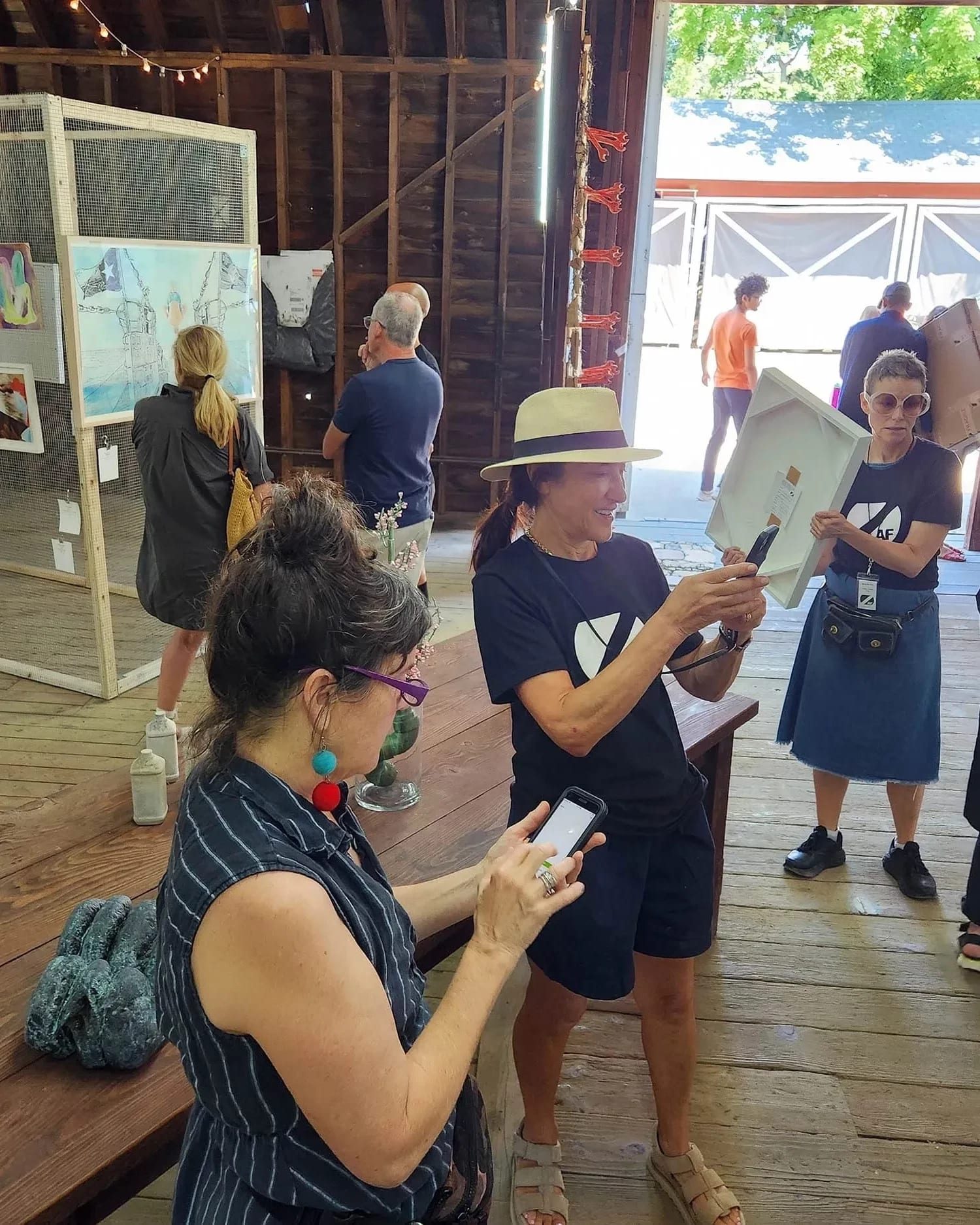 A group of people gathered around a table, with one person holding a paper and others discussing documents.