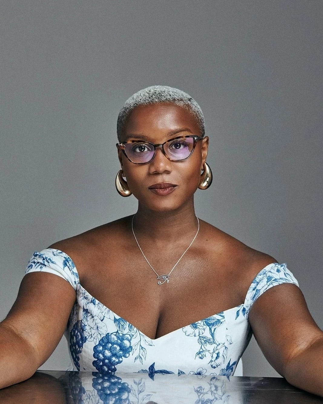 Portrait of a woman, Ja'Tovia Gary, posing in front of a reflective table. 