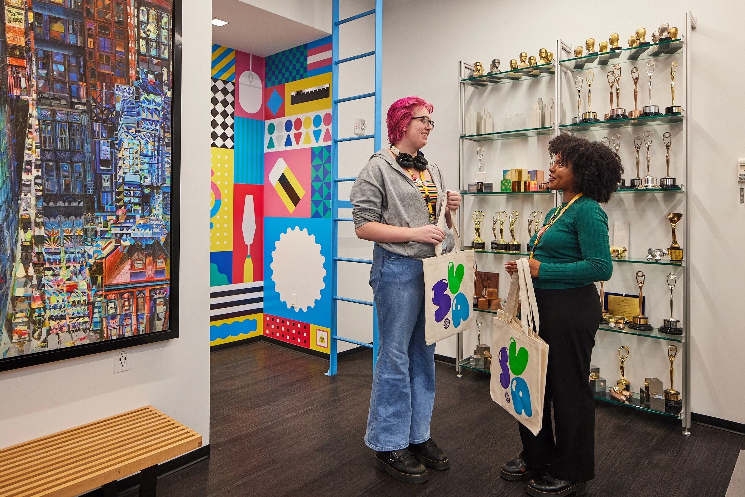 Two students standing by a mural and awards