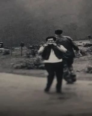 A black and white photograph of men. One seems to be dressed in plainclothes while the others look to be in military gear.