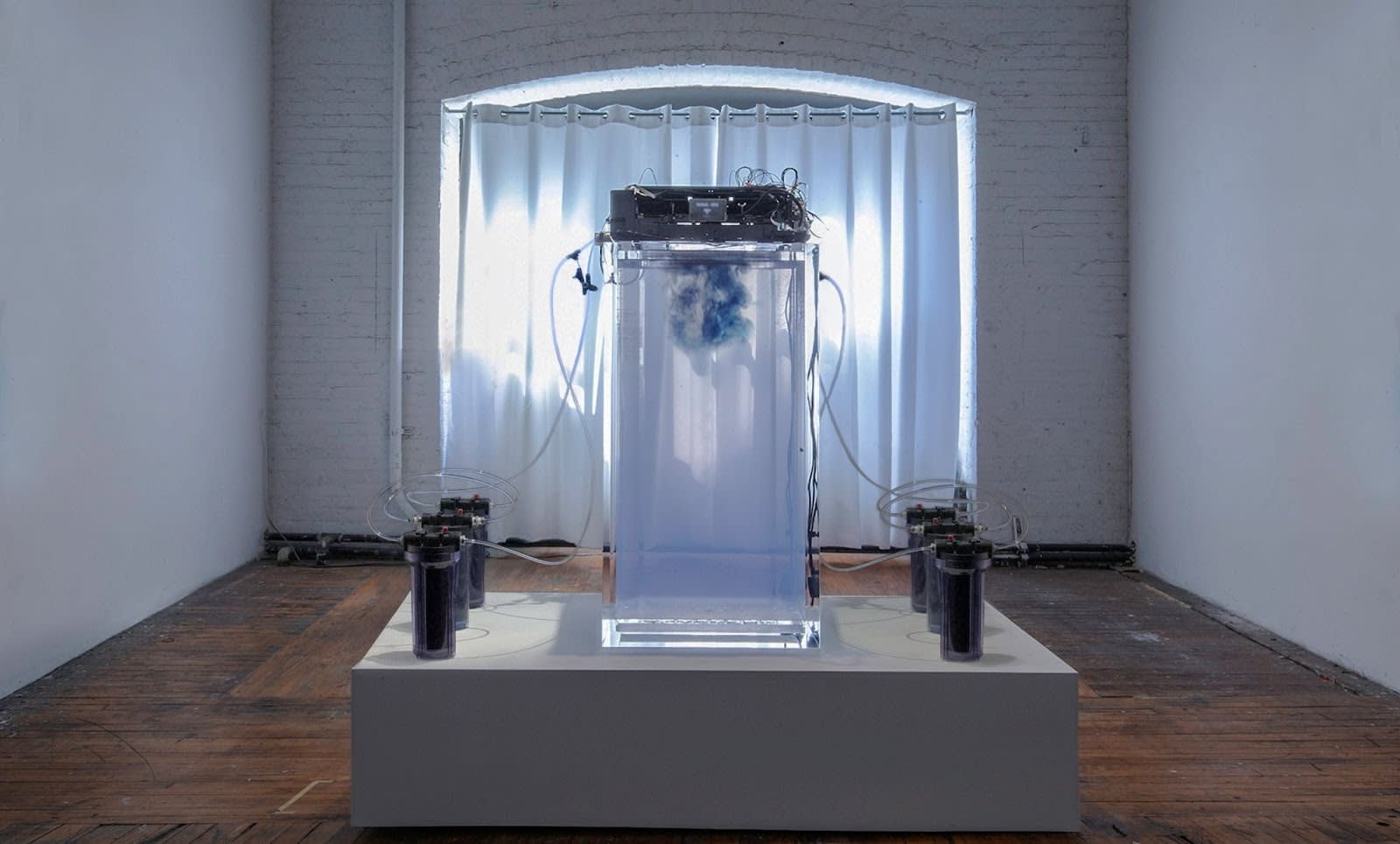 a machine that looks like a clear box with tubes extending outward to small cannisters