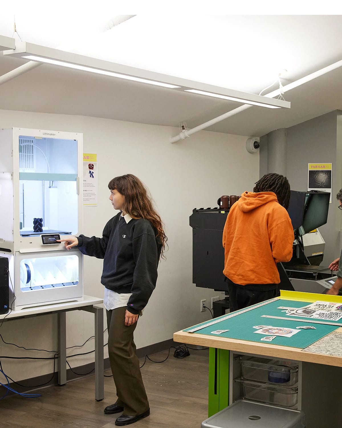 Students and instructors working on various projects in a design fabrication lab.