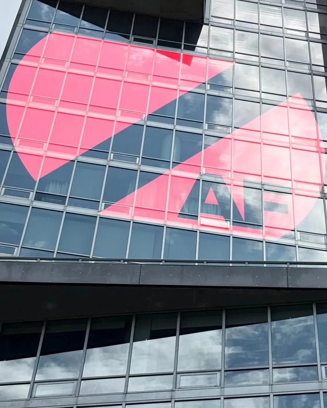 A modern skyscraper facade with the Zero Art Fair logo displayed in its windows.